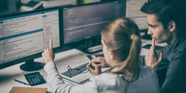 Two people in front of a pc